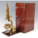 A 19th century lacquered brass monocular microscope, the single adjustable eye-piece above a