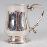 A George II silver bell shaped tankard, having foliate capped S-scroll handle, the body with later