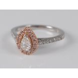A platinum and 18ct rose gold pear shaped cluster ring, featuring a centre pear cut diamond within a