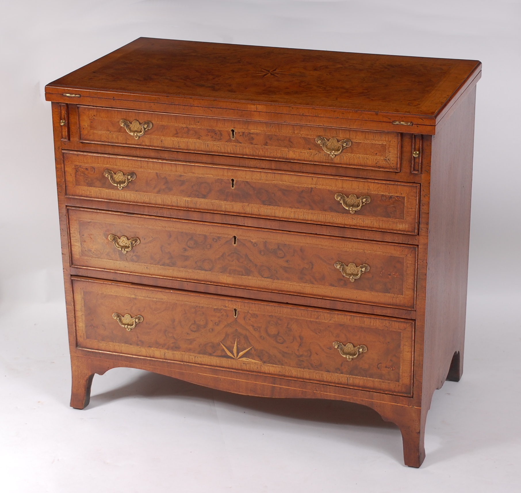 A figured walnut feather and crossbanded bachelors chest, in the George II style, the fold-over