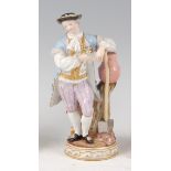 A late 19th century Meissen porcelain figure of a gardener, in standing pose leaning on a shovel,