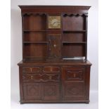 An antique oak house-keepers dresser , the upper section inset with an 11" longcase brass clock dial