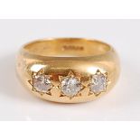 An 18ct yellow gold Gypsy style three stone diamond ring, the three graduated old European cut