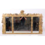 A 19th century carved giltwood chimney mirror, having triple mirrorplate, the swept frame with