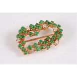 An emerald and diamond brooch by Chaumet, the oval frame set with round emeralds, each approx. 2.8mm
