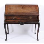 An antique mahogany writing bureau , the sloping fall enclosing well-fitted arcaded interior over