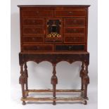 An antique oyster veneered cabinet on stand, the cabinet having an arrangement of ten drawers,