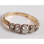 A late Victorian yellow and white metal five stone diamond half hoop ring, the five graduated old