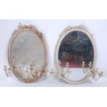 A pair of Victorian white painted and moulded overmantel mirrors, the oval plates surmounted with