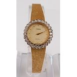 An 18ct yellow gold lady's Omega quartz wristwatch, the watch having a round champagne dot dial