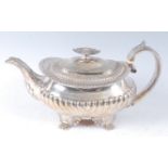 A George IV silver teapot, of squat oval form, having half-reeded decoration, raised on paw feet,