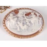 A carved shell cameo brooch depicting children and cherubs playing in a woodland, in 9ct gold mount,