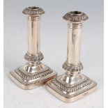 A pair of Edwardian silver table candlesticks, each having a removable sconce to a plain column