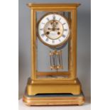 A late 19th century brass cased four glass mantel clock, having white enamel chapter ring, visible