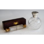 An Edwardian cut glass and silver topped scent bottle, of globular form, the hinged cap embossed