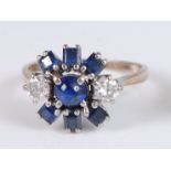 A yellow and white metal, sapphire and diamond circular cluster ring, the centre round cabochon