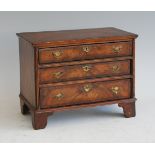 An early 20th century figured walnut and crossbanded apprentice piece miniature chest, in the