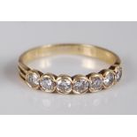 A yellow metal diamond half hoop ring, arranged as seven illusion set brilliant cut diamonds in a