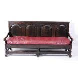 A George III oak settle, the rectangular back with four arched fielded panels above a slatted