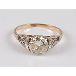 A yellow and white metal single stone diamond ring, the round brilliant cut diamond measuring approx