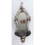 A 19th century German porcelain wall mirror, probably by Meissen, the shaped plate surmounted with a