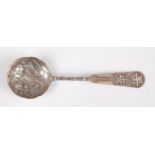 A Japanese Meiji period white metal spoon, the bowl decorated with leaves and bamboo, the stem