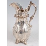 An early Victorian silver jug, of fluted baluster form, having engraved C-scroll decoration,