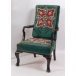 An early 20th century mahogany framed armchair, having Berlin beadwork back and seat, raised on