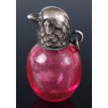 A Victorian novelty scent bottle, having cranberry glass body, the white metal screw-on lid in the