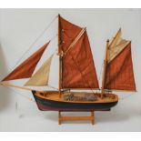 A scale model of a two-masted boat on stand