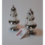 A pair of George V silver pedestal lighthouse pepperettes, h.11cm