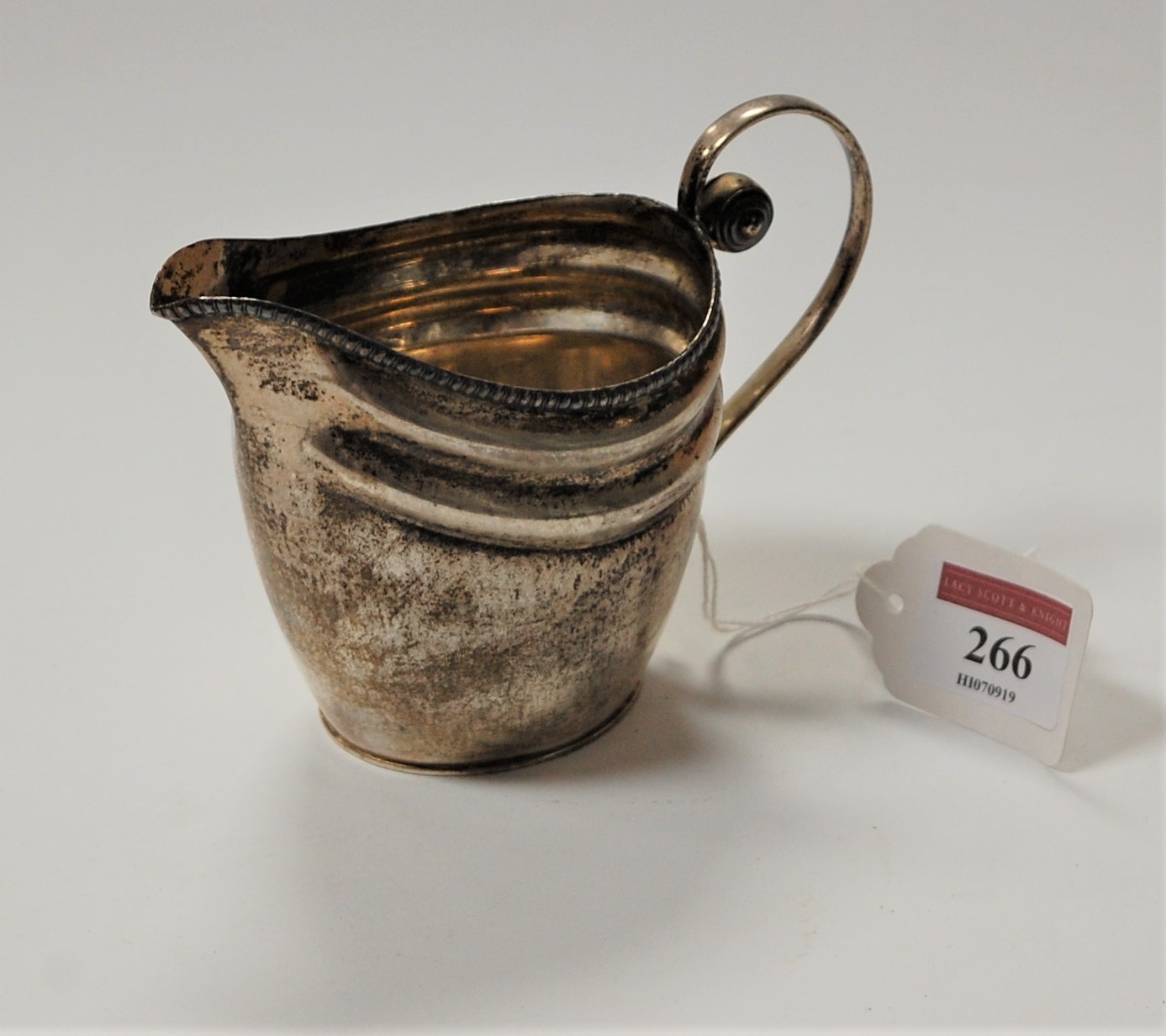 A 19th century white metal cream jug of helmet form being apparently unmarked, 3.2oz, height 10cm