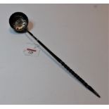 A George III style white metal toddy ladle, the circular bowl repousse decorated with flowers and