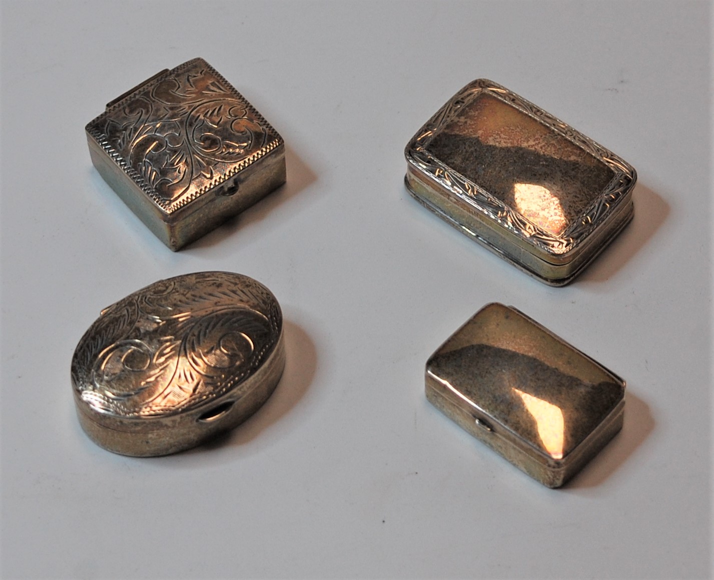 A circa 1900 silver pill box of rectangular form, the hinged cover with engraved border having