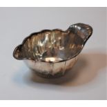 An early 20th century Christoffel white metal sauce boat of shaped oval form with raised candle