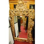 A large Rococo style composite gilt framed rectangular wall mirror, having scalloped shell surmount,