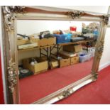 A large contemporary silvered framed rectangular wall mirror, the moulded frame with floral