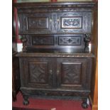 An early 20th century Continental heavily relief carved oak buffet side cupboard, having twin