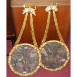 A pair of floral gilt framed classical prints, each framed as ovals