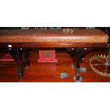 A late Victorian stained pitched pine long bench seat, having a tan leather fixed pad seat and