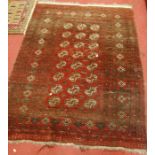 A Persian red ground woollen Bokhara rug (worn), 175 x 130cm