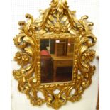 An early 20th century heavy floral giltwood framed wall mirror, in the Rococo taste, 122 x 90cm