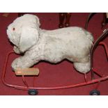 A mid-20th century childs plush upholstered and metal framed push-along dog, lengh 86cm