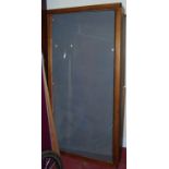 A large stained pine and slopefront hinged museum display cabinet, raised on folding end supports,