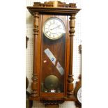 An early 20th century Vienna walnut droptrunk wall clock, having twin weights and pendulum, approx