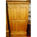A modern pine twin panelled double door wardrobe, having single long lower drawer, w.103cm