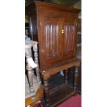 A joined and linenfold panelled oak double door buffet side cupboard, raised on ring turned supports