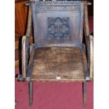 An early 20th century relief carved oak panelled seat Glastonbury chair, w.70cm