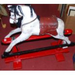 A child's dapple grey rocking horse with leather tack and on painted stand (for restoration)