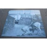 A large monochrome photograph print on canvas depicting a circus performer on horseback, unframed,